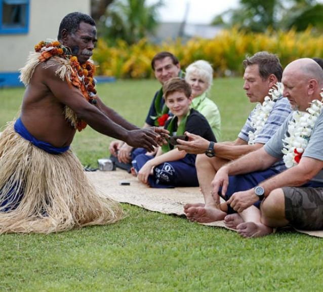 traditional kava ceremony with a South Pacific native presenting a cup of kava to a tourist