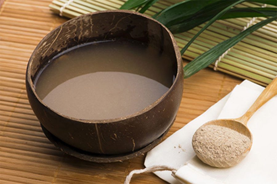 Kava root drink in kava shell or bilo with spoon of kava powder alongside
